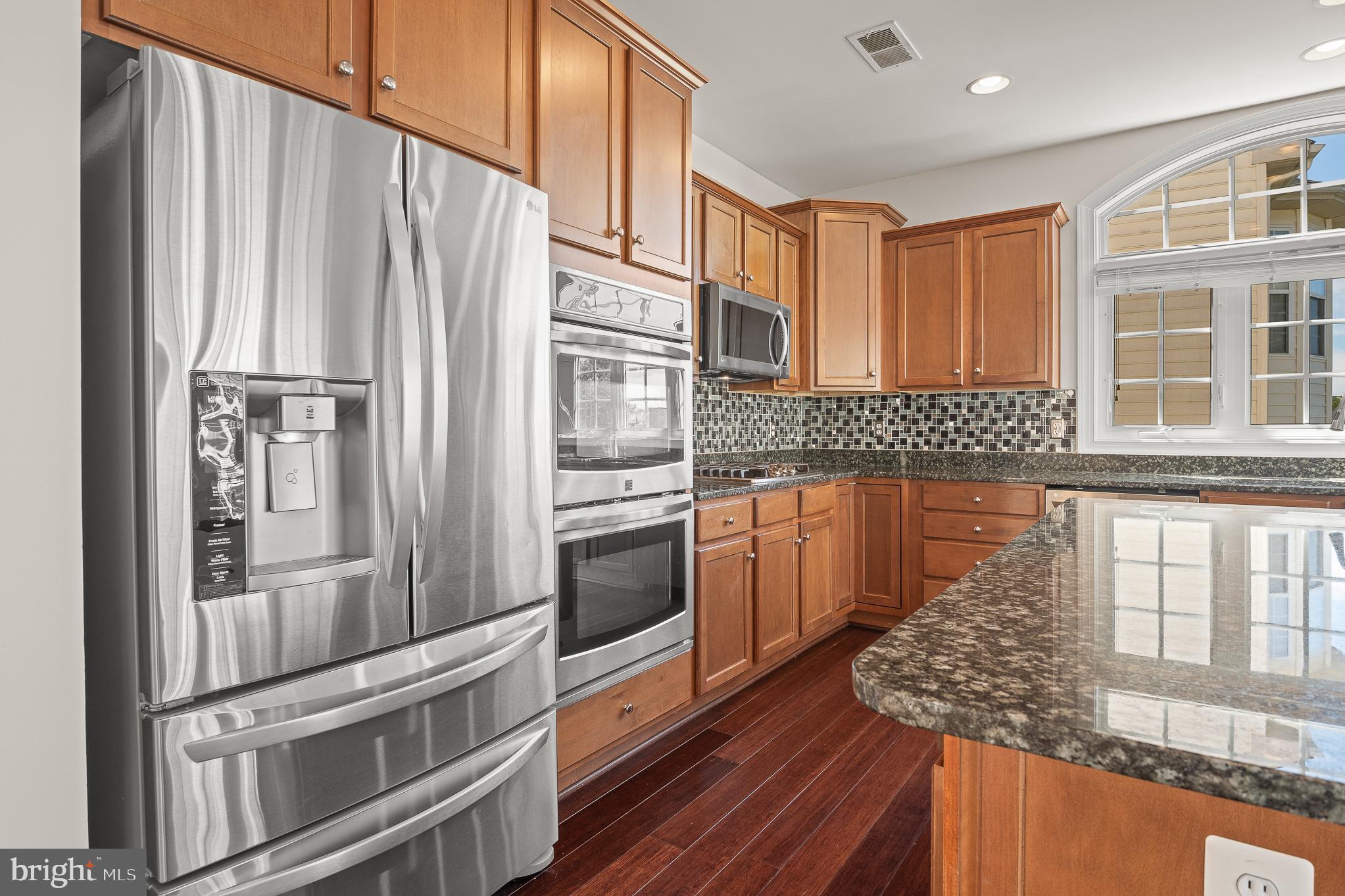 16862 Reef Knot Way Woodbridge, VA 22191 - Photo 25 of 99 a kitchen with stainless steel appliances granite countertop a refrigerator and a stove top oven