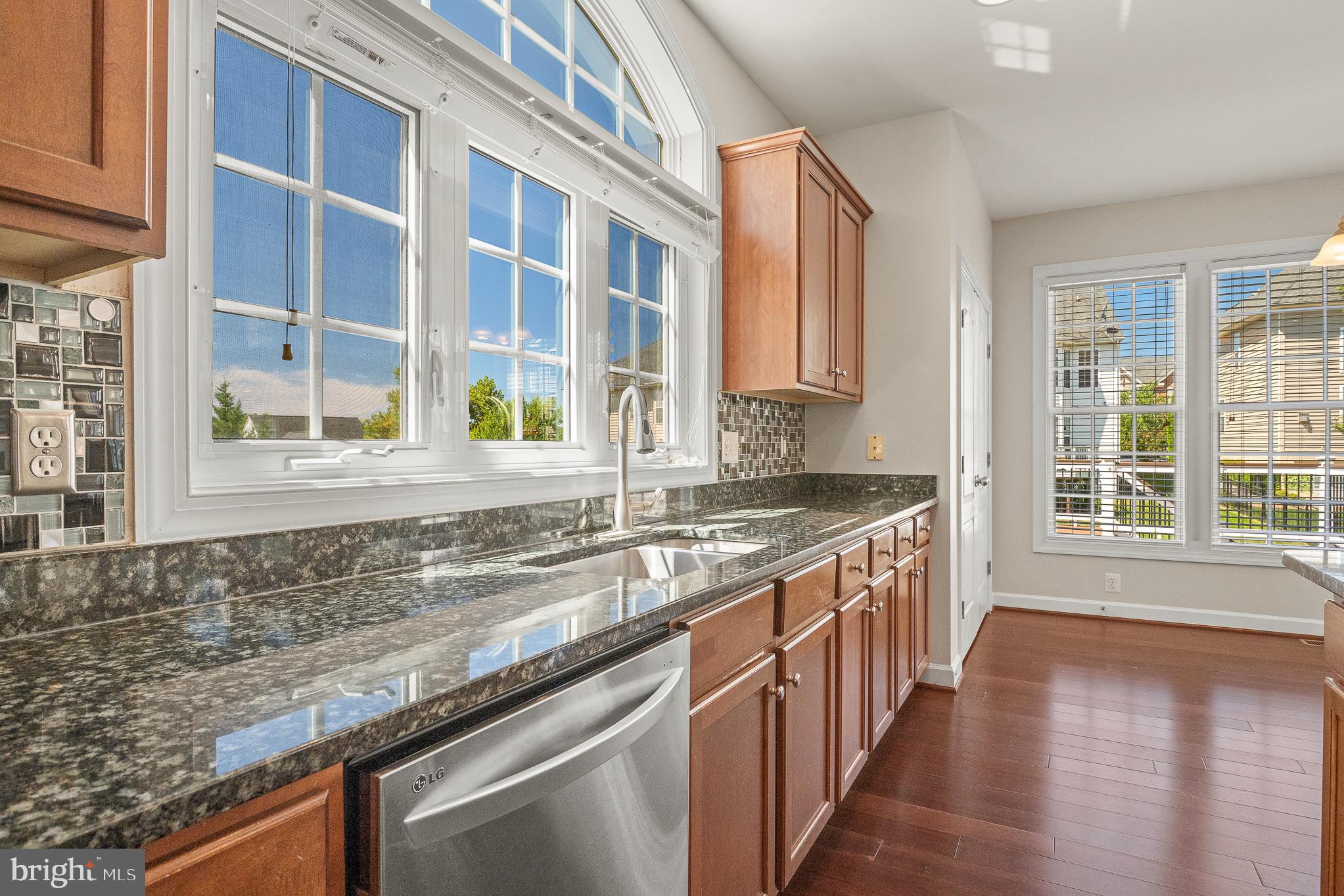 16862 Reef Knot Way Woodbridge, VA 22191 - Photo 27 of 99 a kitchen with stainless steel appliances granite countertop a sink a stove and a wooden cabinets