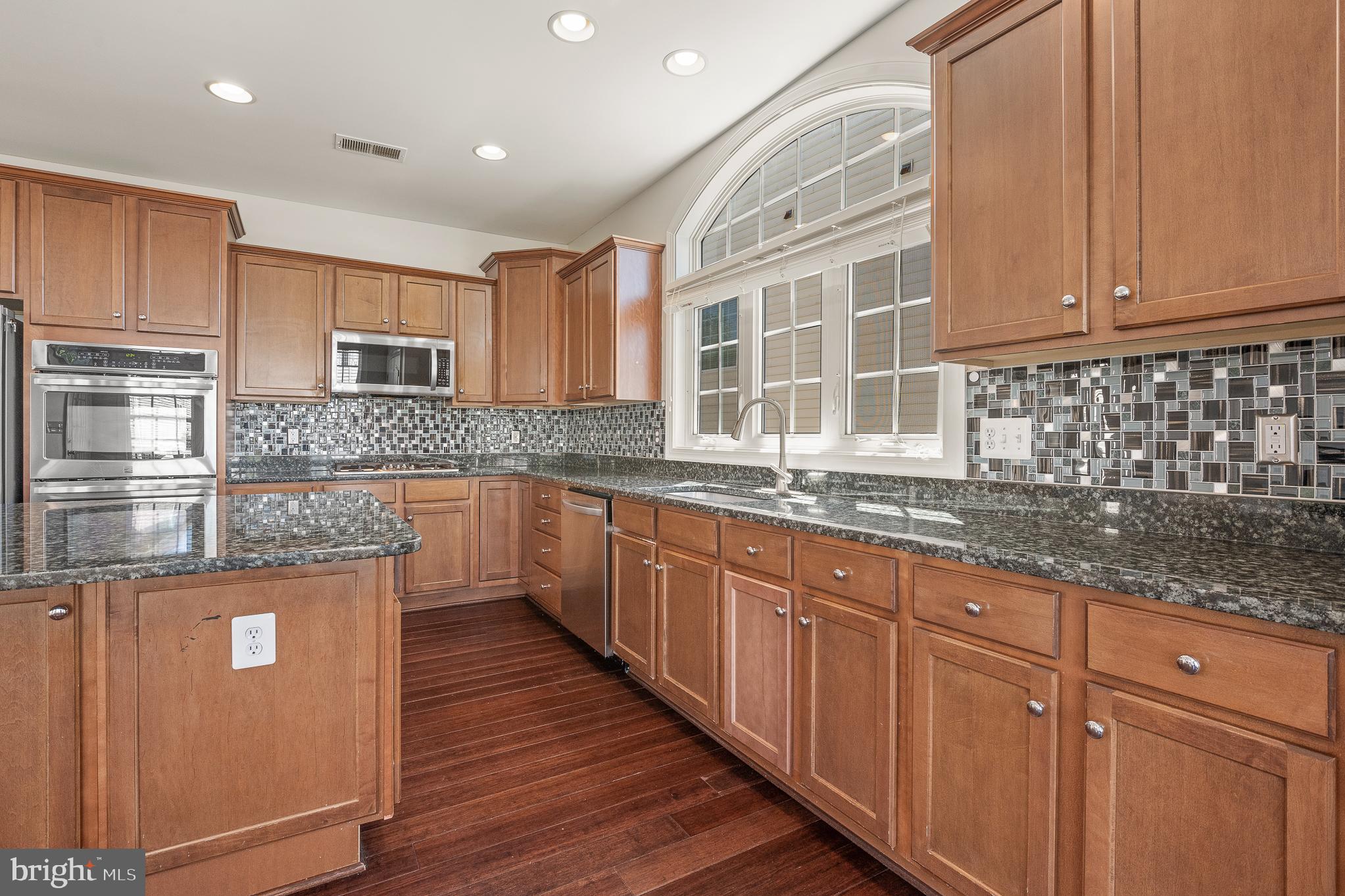 16862 Reef Knot Way Woodbridge, VA 22191 - Photo 29 of 99 a kitchen with stainless steel appliances granite countertop a sink stove and cabinets