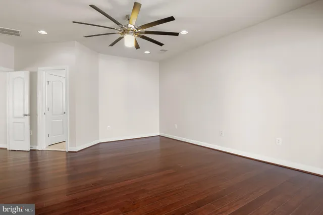 a view of an empty room with wooden floor