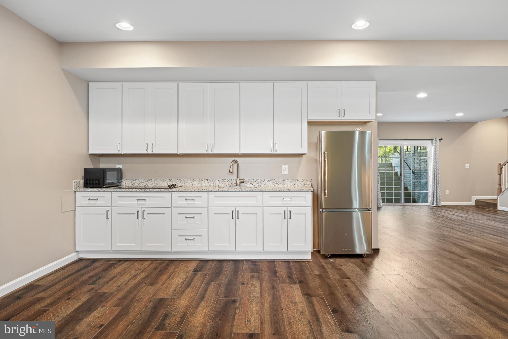16862 Reef Knot Way Woodbridge, VA 22191 - Photo 70 of 99 a kitchen with stainless steel appliances granite countertop a refrigerator sink and white cabinets