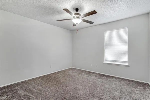 an empty room with a window and a ceiling fan