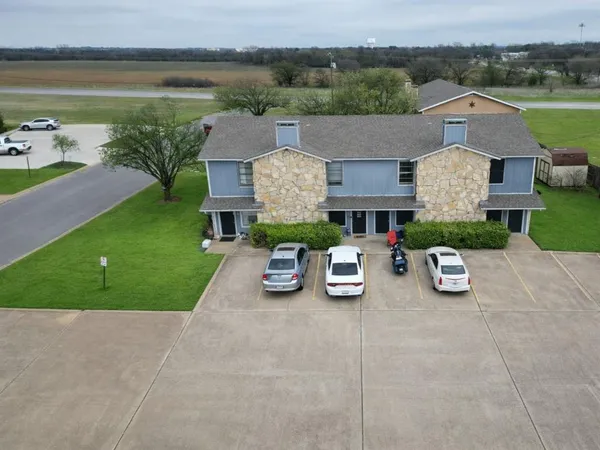 a front view of a house with garden and plants