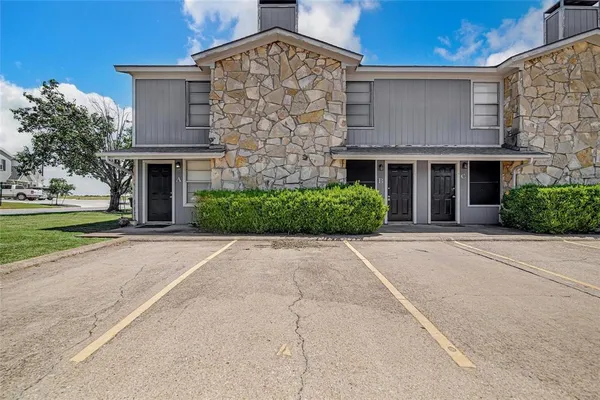 front view of a brick house with a yard