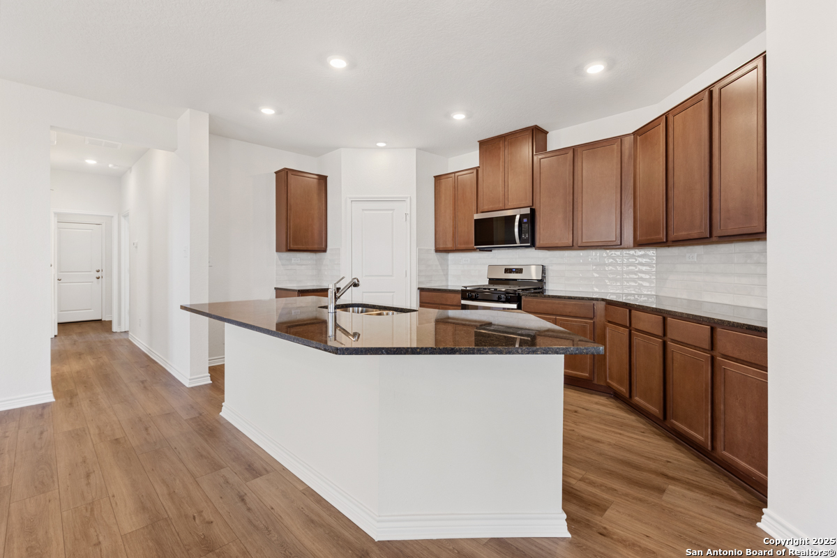 10034 Jagger Avenue Converse, TX 78109 - Photo 5 of 6 a kitchen with stainless steel appliances granite countertop a sink stove and microwave
