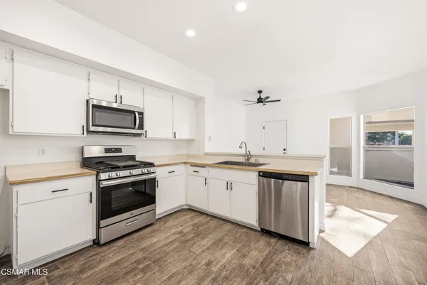 a kitchen with granite countertop a stove top oven sink and cabinets