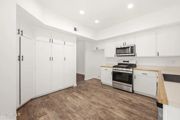 a kitchen with stainless steel appliances a refrigerator stove and microwave