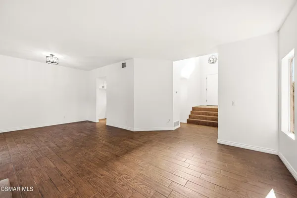 a view of an empty room with wooden floor