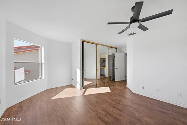 a view of a room with a large window and wooden floor