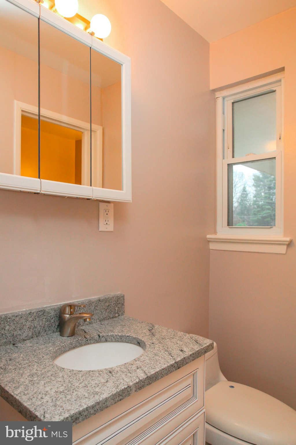 5917 Atteentee Road Springfield, VA 22150 - Photo 16 of 30 a bathroom with a granite countertop sink and a mirror