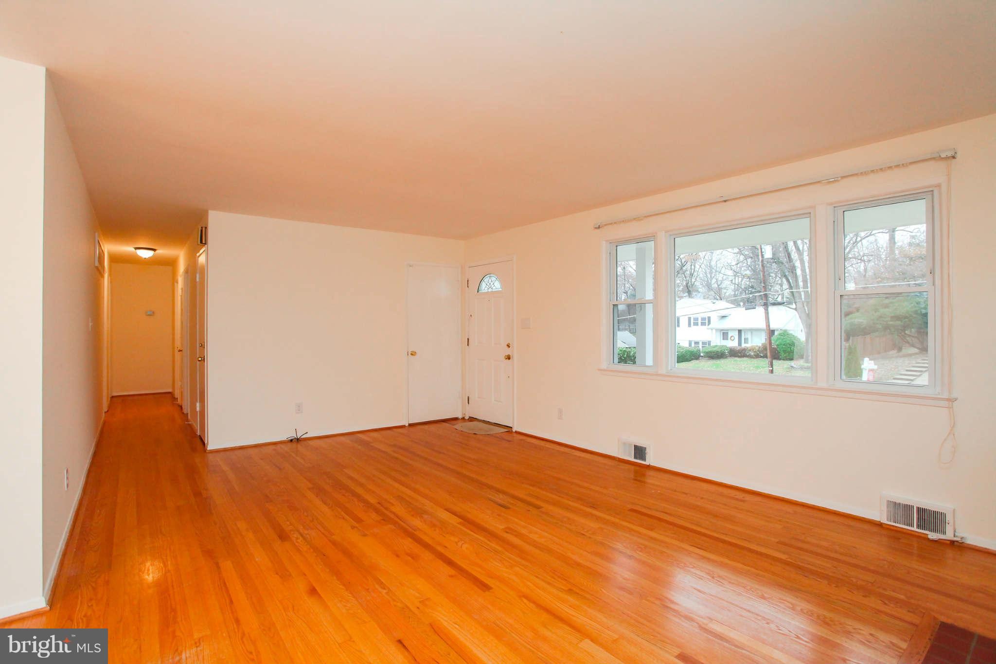5917 Atteentee Road Springfield, VA 22150 - Photo 4 of 30 a view of an empty room with wooden floor and a window