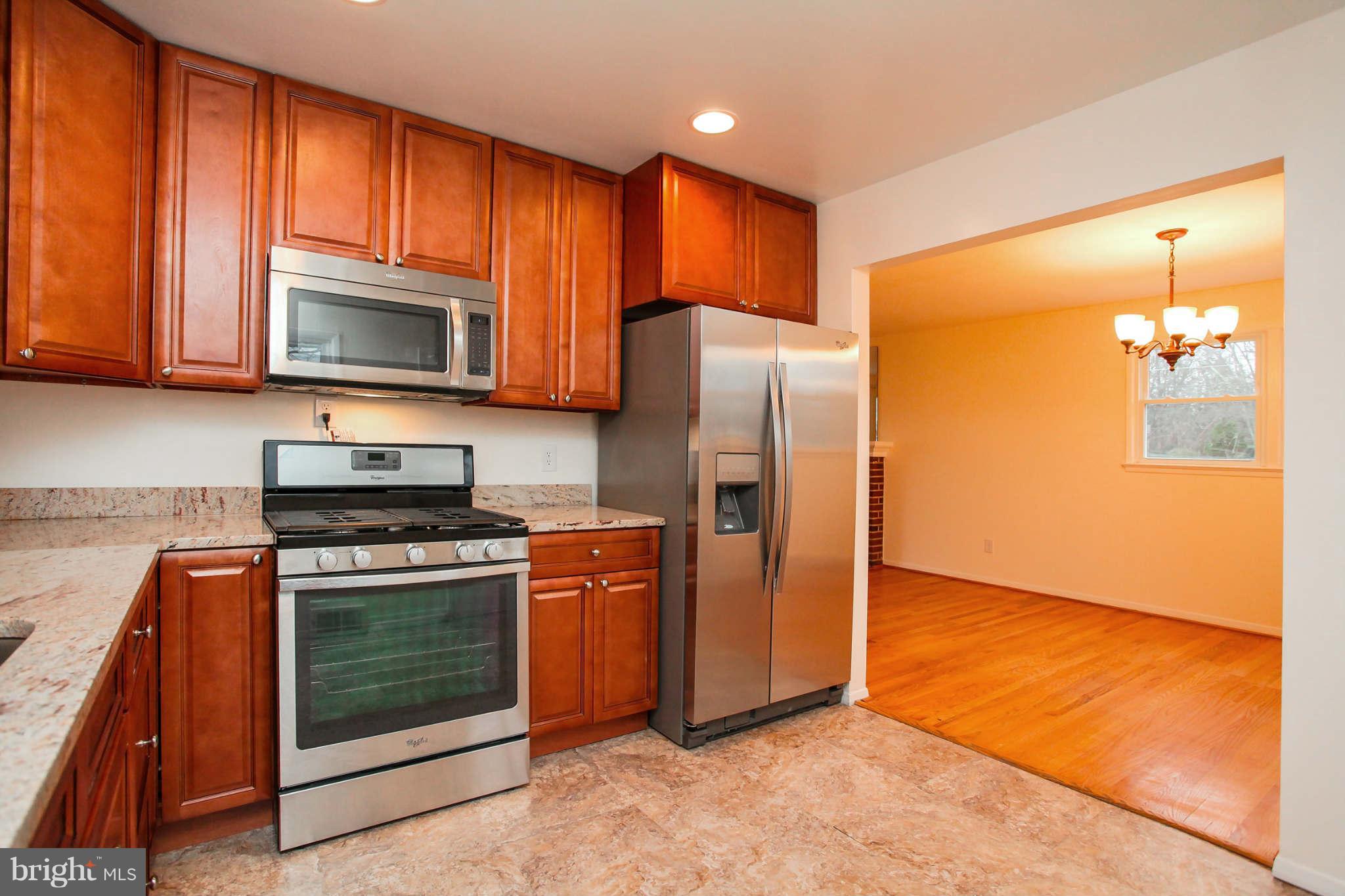 5917 Atteentee Road Springfield, VA 22150 - Photo 8 of 30 a kitchen with granite countertop wooden cabinets stainless steel appliances and a window