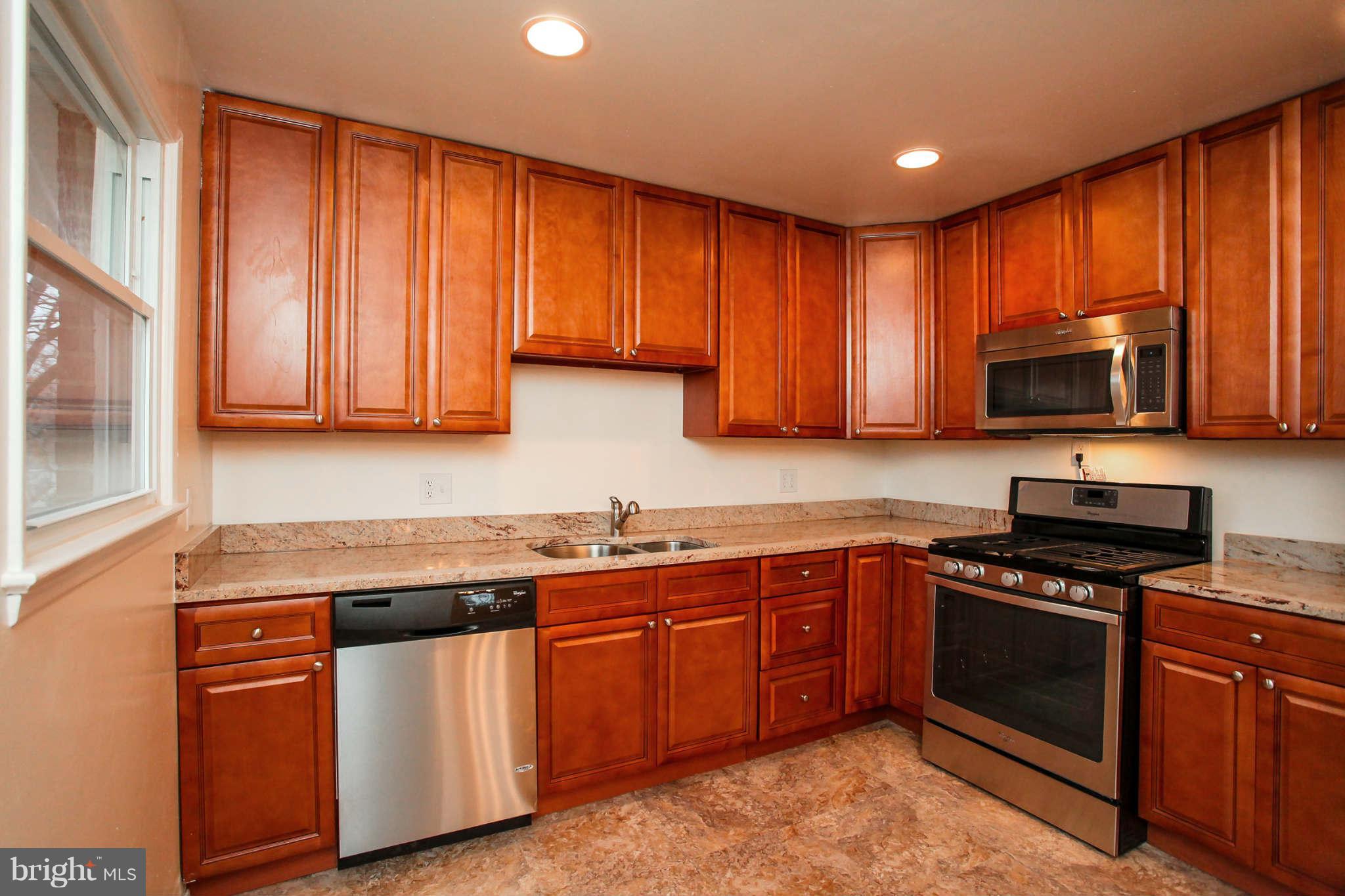 5917 Atteentee Road Springfield, VA 22150 - Photo 9 of 30 a kitchen with stainless steel appliances granite countertop wooden cabinets a stove top oven a sink and dishwasher