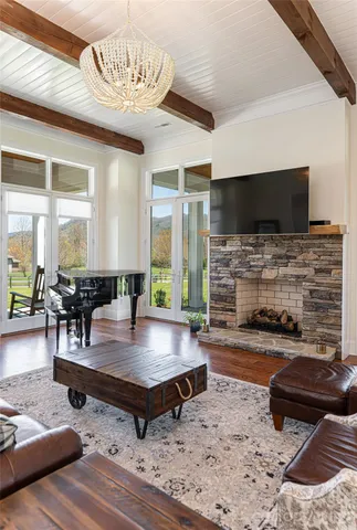 a living room with furniture wooden floor and a chandelier