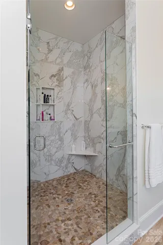 a bed sitting in a spacious bedroom next to a window