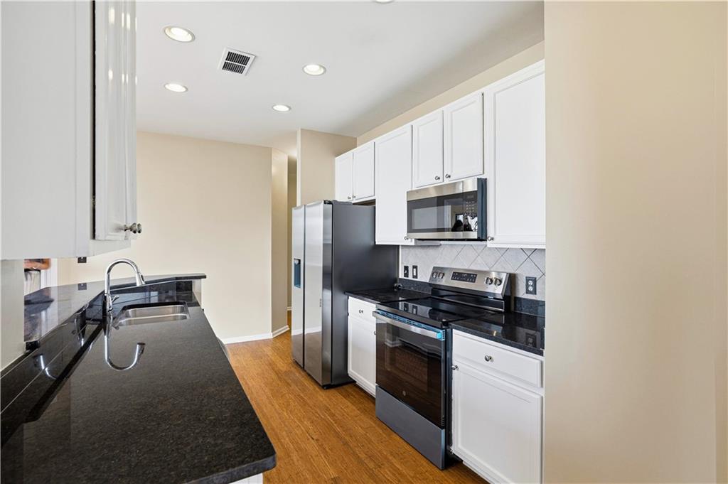 3040 Peachtree Road Northwest, Unit 1503 Atlanta, GA 30305 - Photo 10 of 38 a kitchen with granite countertop a stove sink and refrigerator
