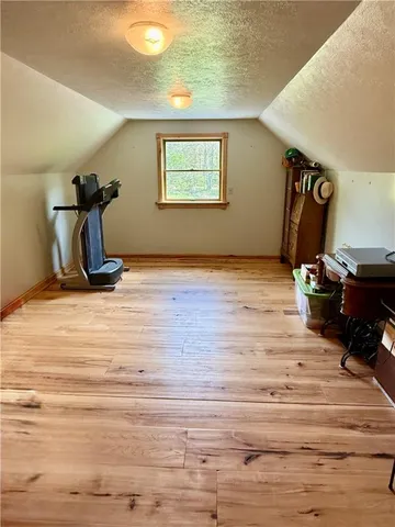 a room with gym equipment and wooden floor