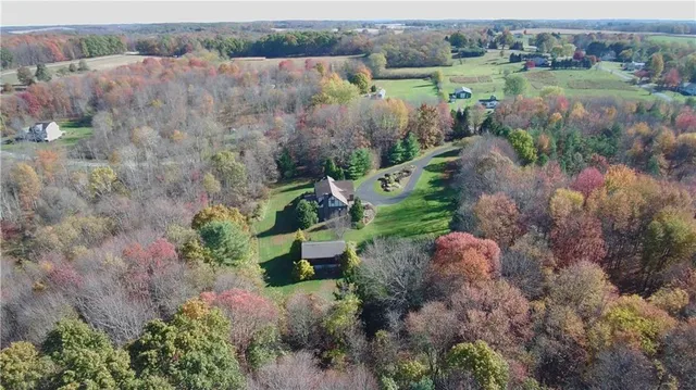 an aerial view of a houses with outdoor space and trees