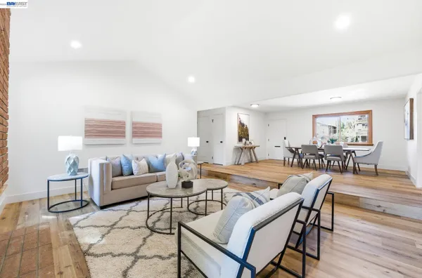a living room with furniture a table and a large window