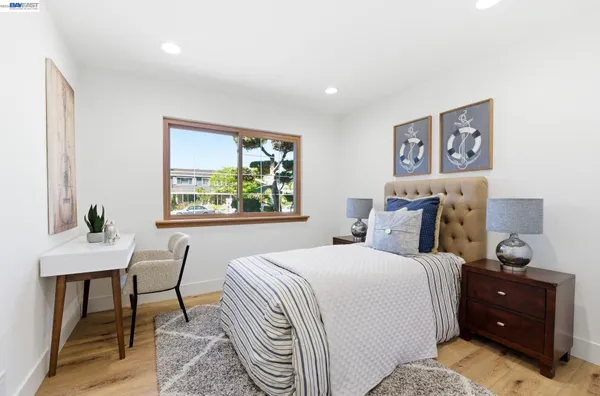 a view of a bedroom with furniture and wooden floor