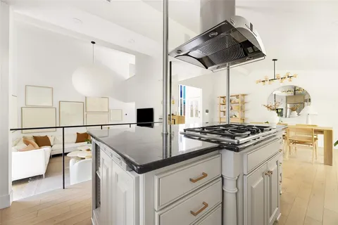 a kitchen with a stove cabinets and wooden floor
