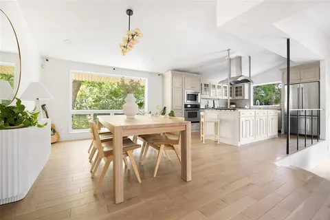 a dining room with furniture and a large window
