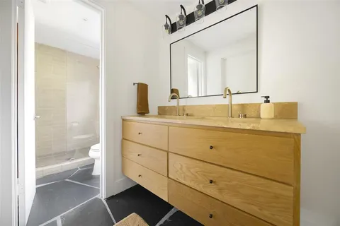 a bathroom with a double vanity sink mirror and bathtub