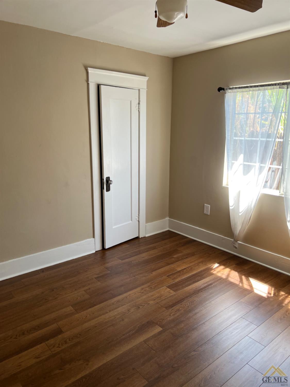 Undisclosed Address Taft, CA 93268 - Photo 10 of 21 a view of an empty room with wooden floor and a window