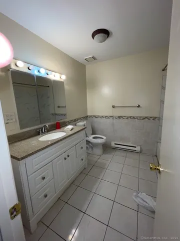a spacious bathroom with a granite countertop sink a toilet and a mirror
