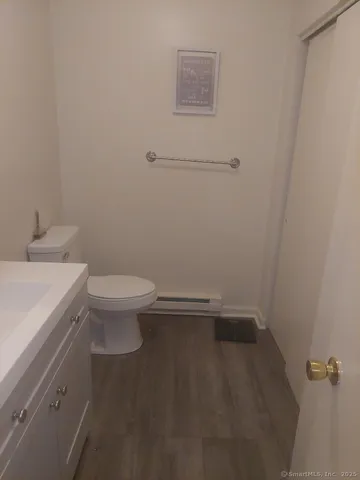 a bathroom with a granite countertop toilet and a sink
