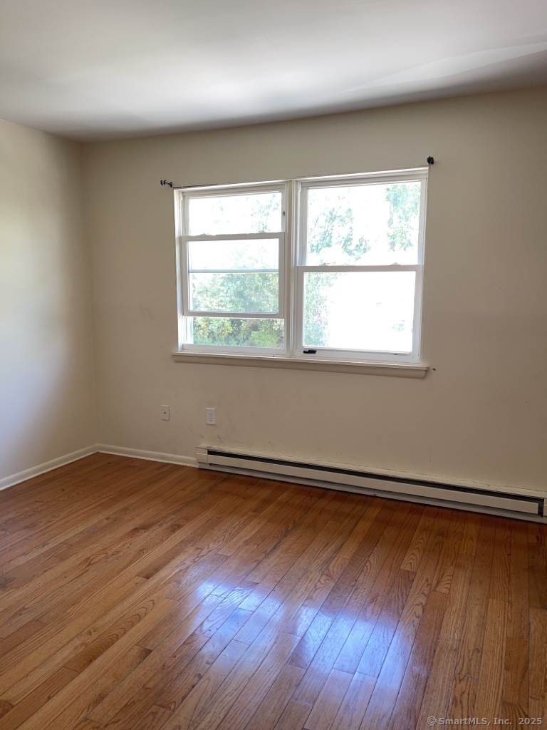 7 Eden Drive, Unit 9 Danbury, CT 06810 - Photo 5 of 9 an empty room with wooden floor and windows