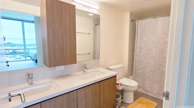 a bathroom with a sink toilet double vanity and window