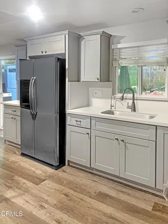 a kitchen with a sink cabinets stainless steel appliances and a window