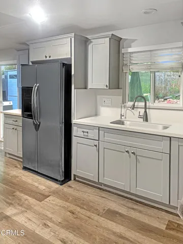 a kitchen with a sink cabinets stainless steel appliances and a window