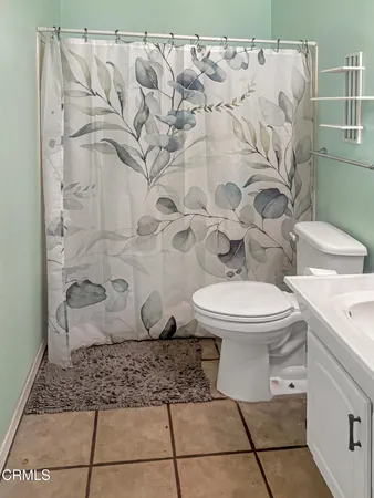 a white toilet sitting next to a shower curtain