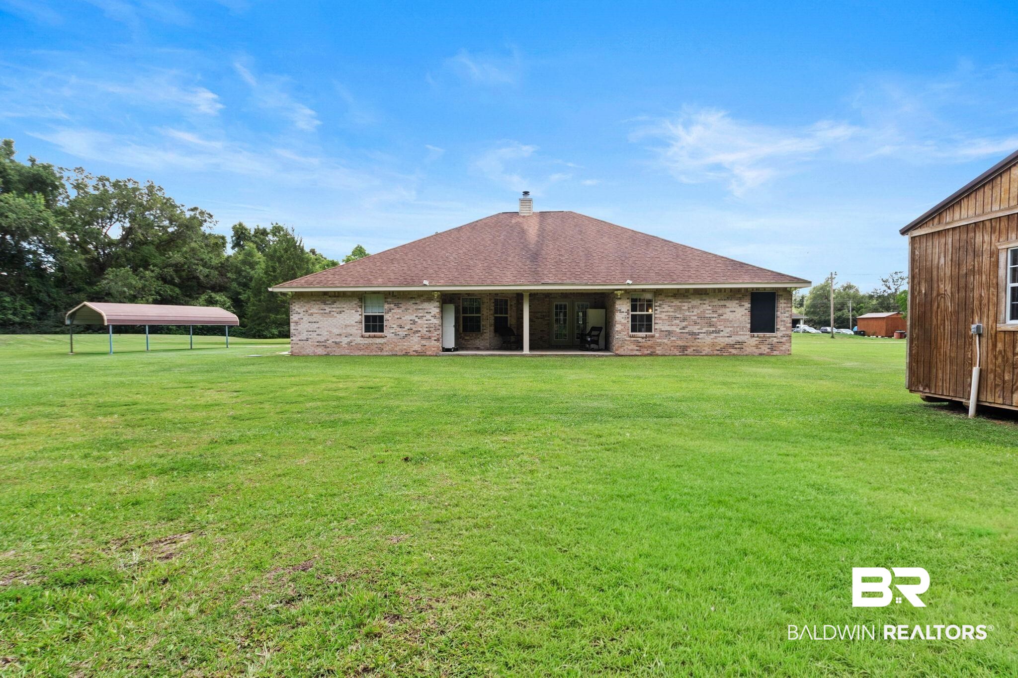 16151 Tolbert Road Bay Minette, AL 36507 - Photo 58 of 74 Expansive backyard featuring a manicured lawn, a detached storage shed, and a covered carport structure