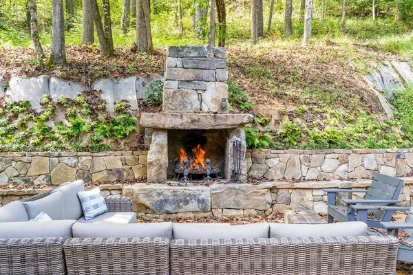 a view of a patio with table and chairs potted plants and large tree