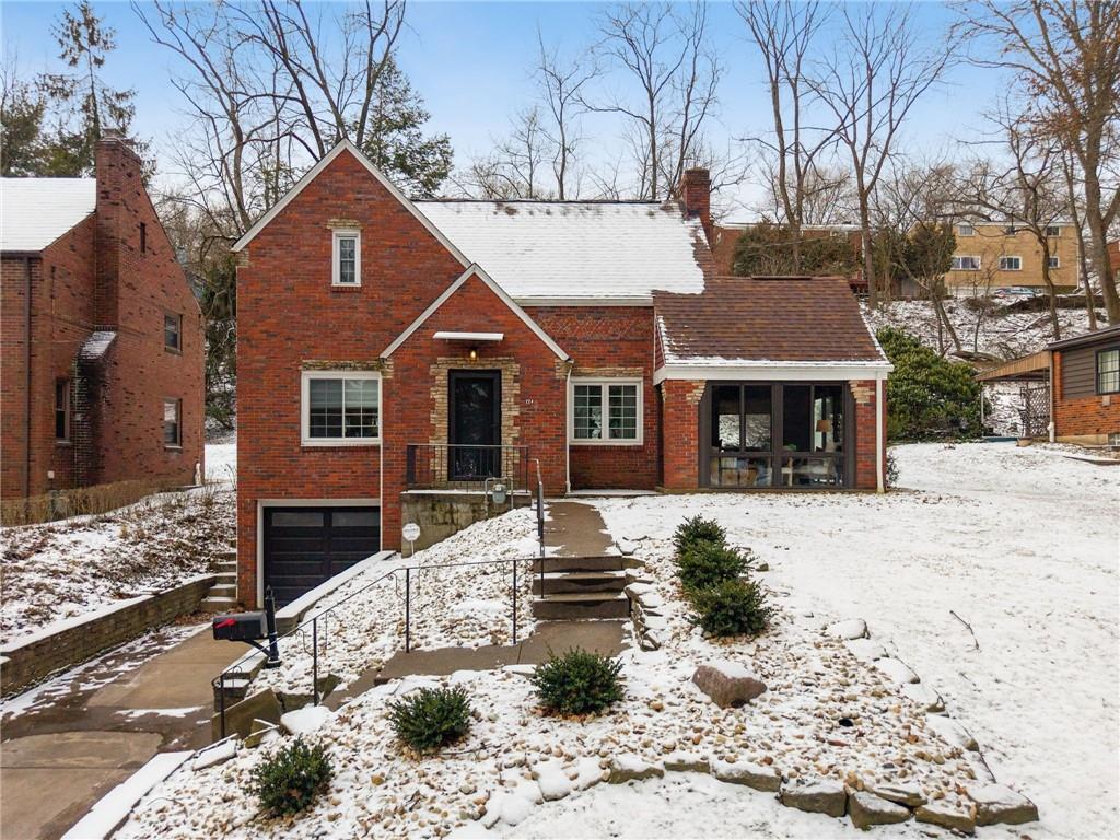 a front view of a house with a yard covered in snow
