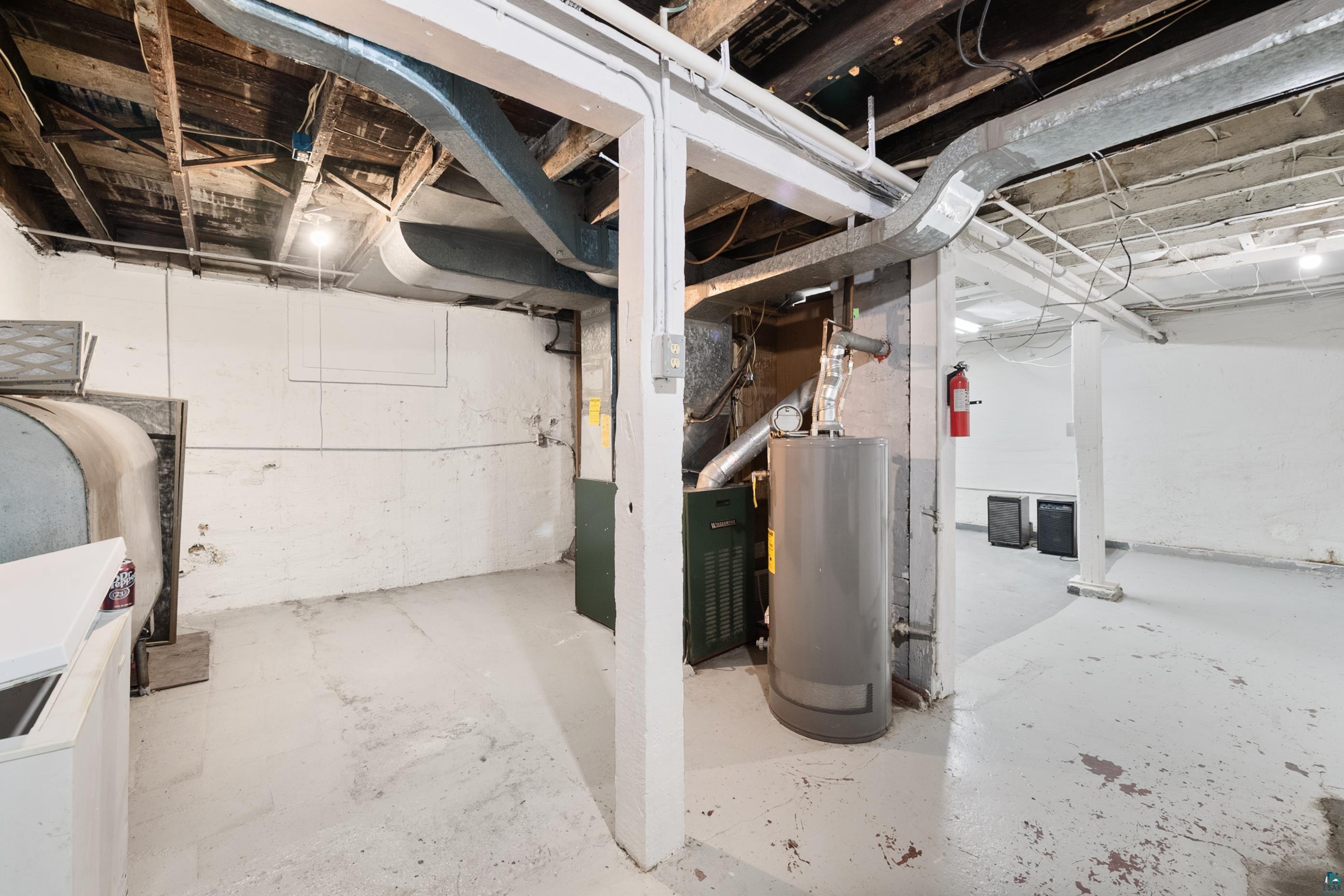 3067 Restormel Street Duluth, MN 55806 - Photo 19 of 25 Basement utility space featuring a water heater, furnace, and exposed ceiling joists