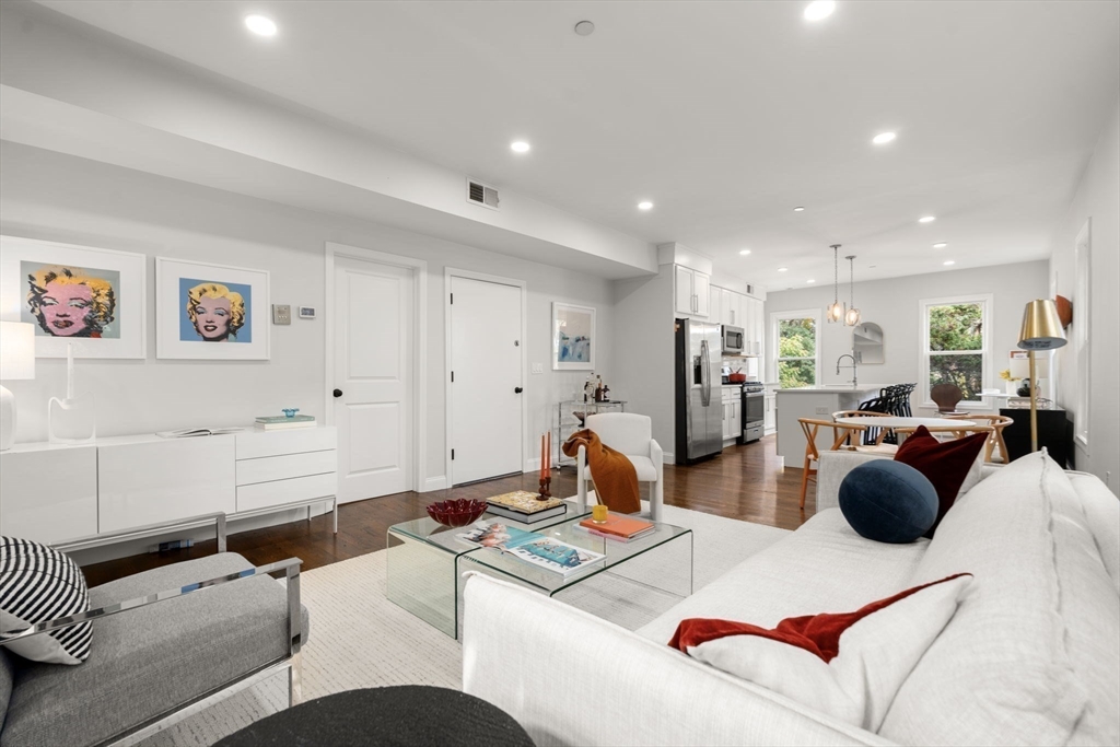 a living room with furniture and a view of kitchen
