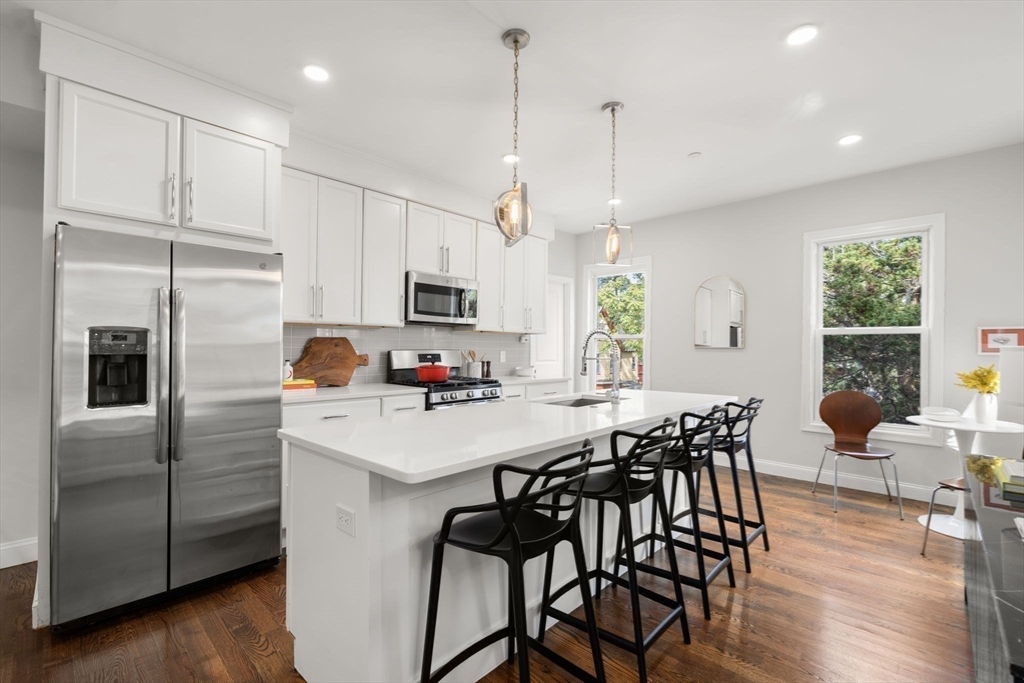 4 Wyoming Street, Unit 2 Boston, MA 02121 - Photo 6 of 23 a kitchen with stainless steel appliances a white table chairs and a refrigerator