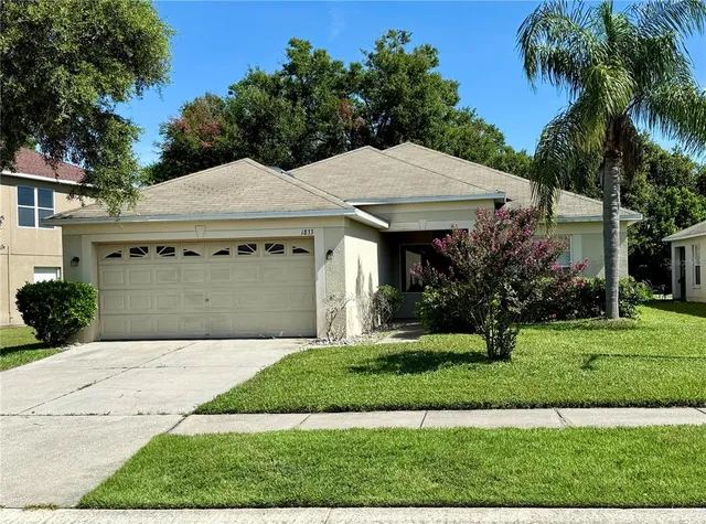 a front view of a house with a garden and trees