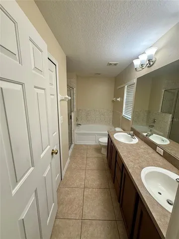 a bathroom with a granite countertop sink a mirror and a bathtub