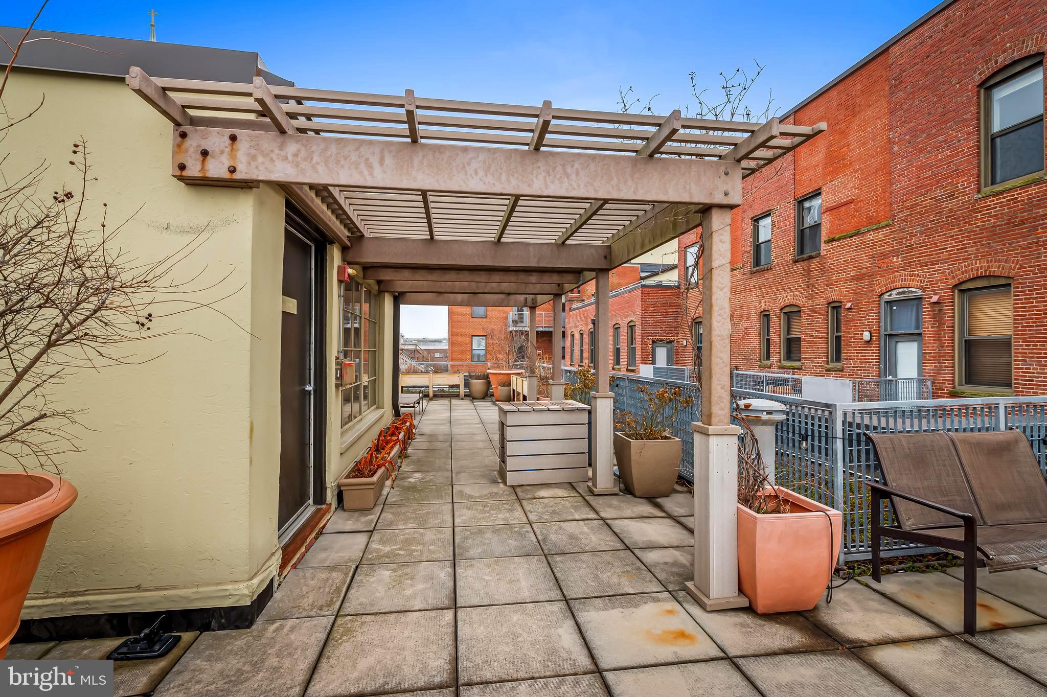 1211 Light Street, Unit 103 Baltimore, MD 21230 - Photo 23 of 31 a view of a patio with table and chairs potted plants