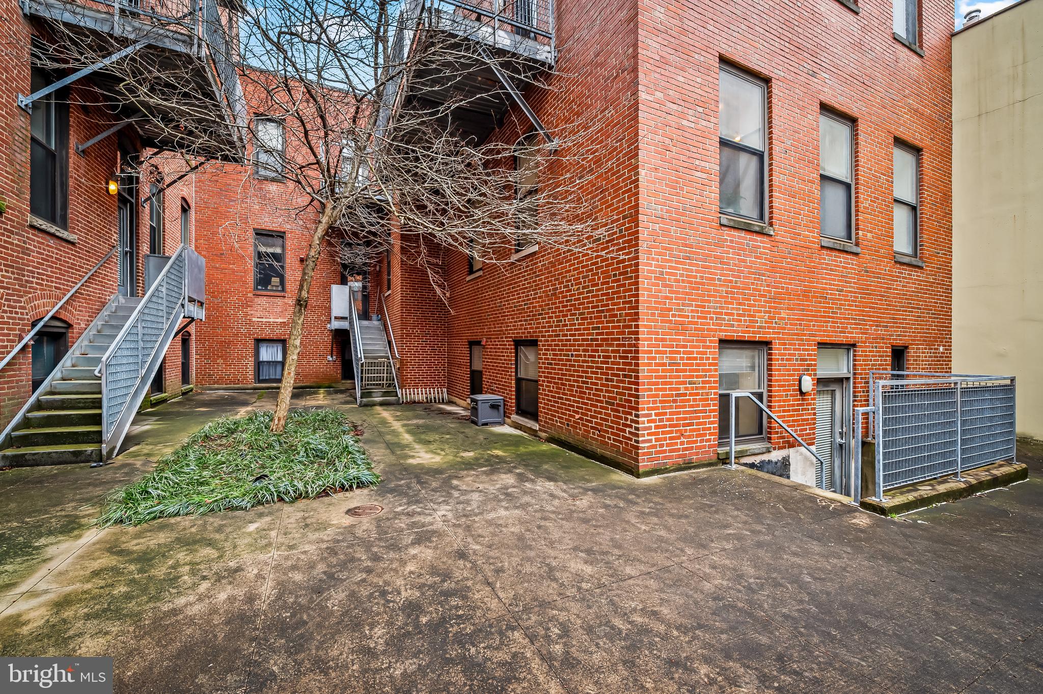 1211 Light Street, Unit 103 Baltimore, MD 21230 - Photo 26 of 31 front view of a house with a yard and wooden fence