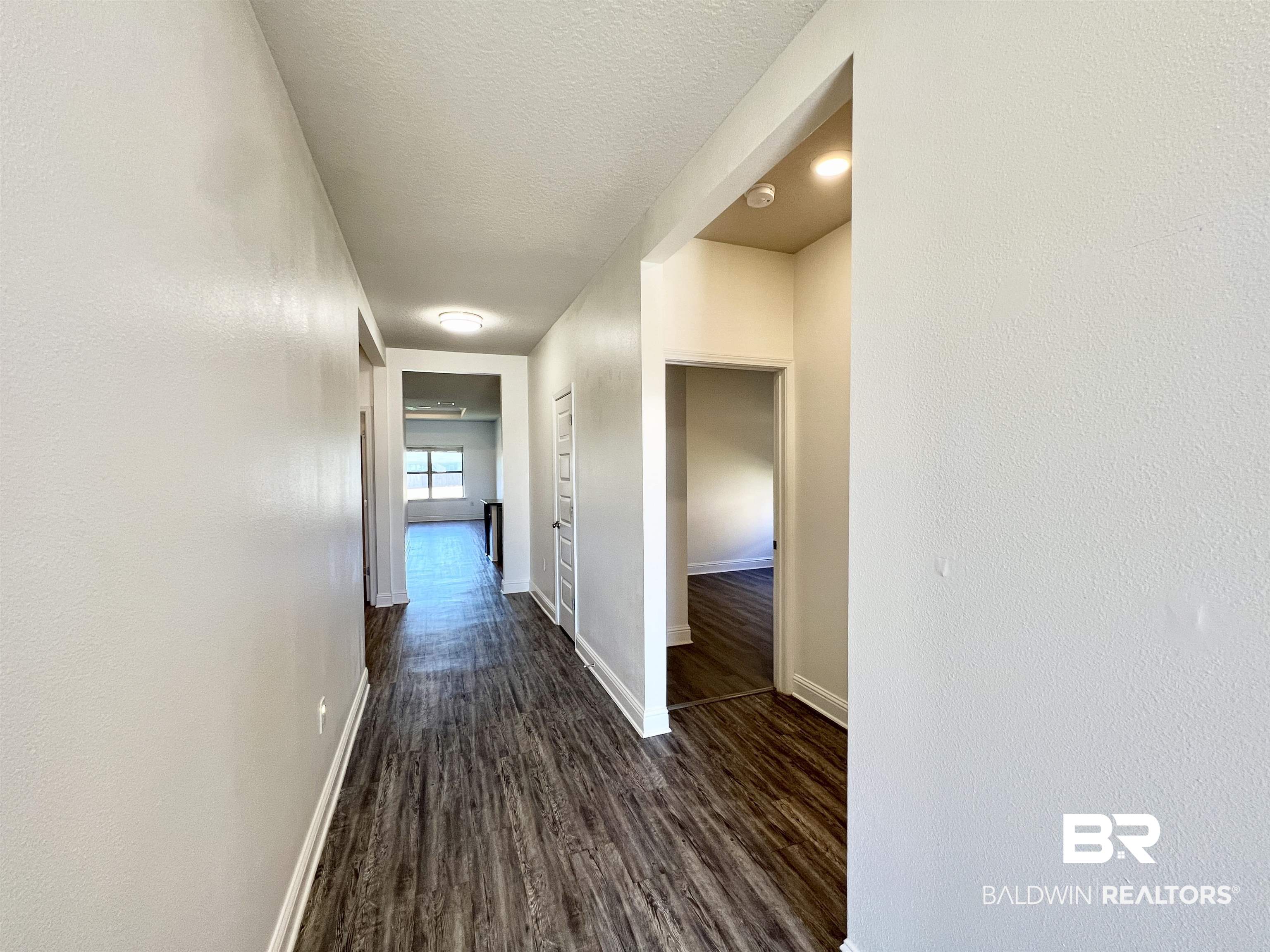 24785 Slater Mill Road Daphne, AL 36526 - Photo 8 of 46 Hallway with dark wood-type flooring and a textured ceiling
