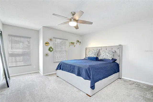 a bedroom with a bed and a ceiling fan