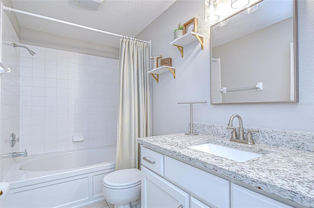 228 Hardcastle Place Valrico, FL 33594 - Photo 13 of 22 a bathroom with a granite countertop sink a toilet and shower