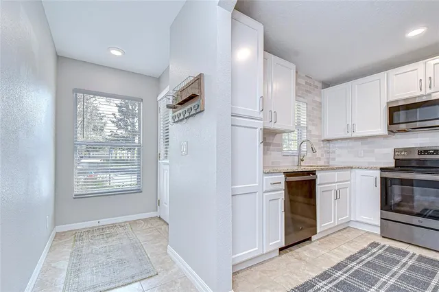 a kitchen with stainless steel appliances granite countertop a stove a sink and a refrigerator