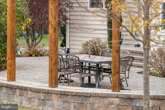 a kitchen with stainless steel appliances granite countertop wooden cabinets a dining table and chairs